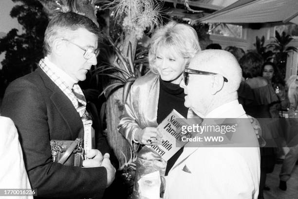 Roddy McDowall, Angie Dickinson, and Irving "Swifty" Lazar attend a party in Beverly Hills, California, on June 25, 1987.