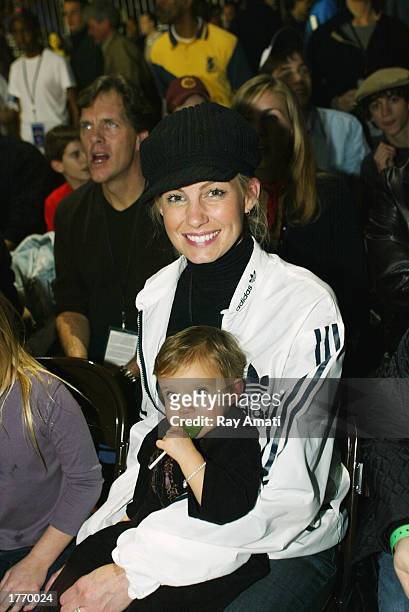 Music artist Faith Hill and her child pose for a photo while watching the Celebrity Game at the NBA Jam Session at the Georgia World Congress Center...