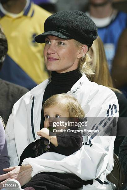 Musician Faith Hill and her child watch the Celebrity Game at NBA Jam Session during the 2003 NBA All Star Weekend at the Georgia World Congress...