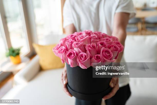 man holding out a bunch of pink roses, close-up of hand - man holding out flowers stock pictures, royalty-free photos & images