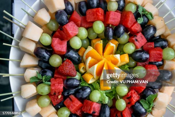 floral pattern fruit skewers on white plate - fruit loops stock pictures, royalty-free photos & images