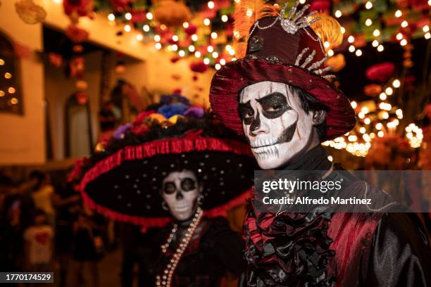 Couple disguised as 'La Catrina' and 'Catrin', characters created by the Mexican engraver and illustrator Jose Guadalupe Posada, pose for a portrait...