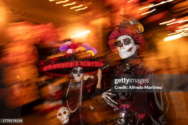 Couple disguised as 'La Catrina' and 'Catrin', characters created by the Mexican engraver and illustrator Jose Guadalupe Posada, pose for a portrait...