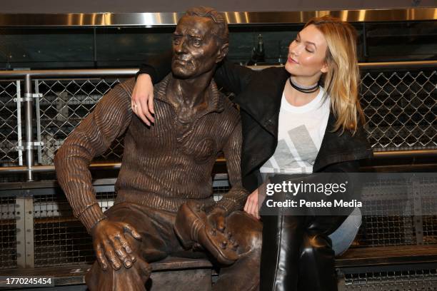 Karlie Kloss with sculpture of Adolf Dassler