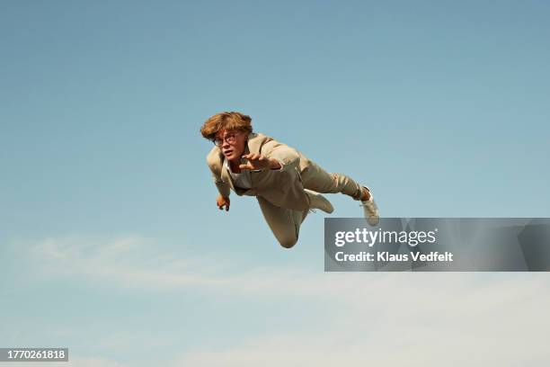 low angle view of young man flying in mid-air - zapatos-beige fotografías e imágenes de stock