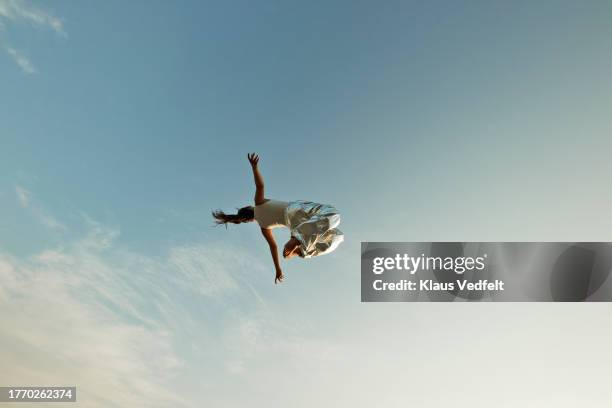 woman falling from sky with arms outstretched - frauenpower stock-fotos und bilder