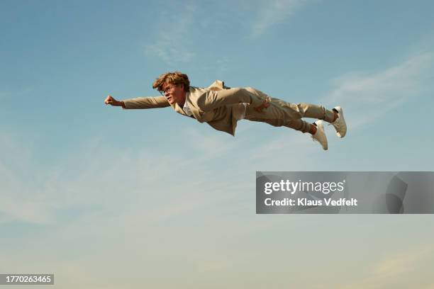 man imitating superman pose in mid-air - acrobate photos et images de collection