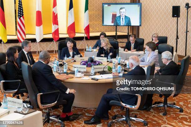 Ukraine's Foreign Minister Dmytro Kuleba is seen on a monitor as Germany's Foreign Minister Annalena Baerbock, US Secretary of State Antony Blinken,...