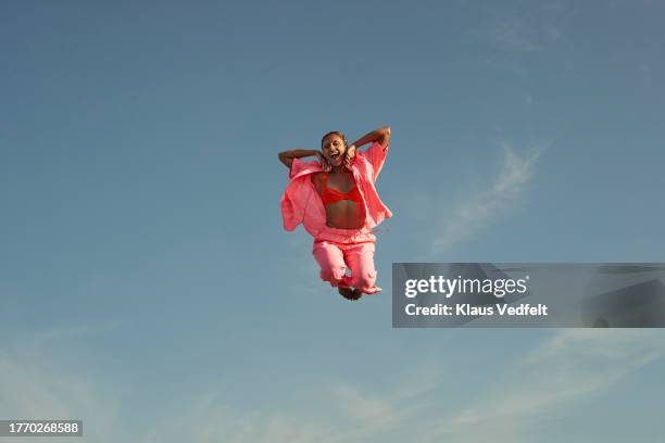 carefree woman jumping in mid-air - acrobate photos et images de collection