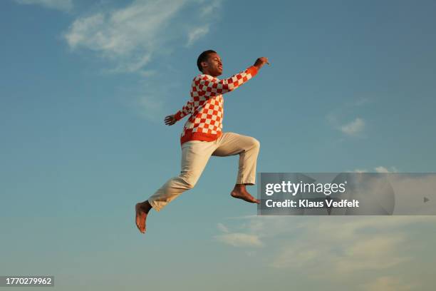 smiling man levitating in mid-air - agilité photos et images de collection