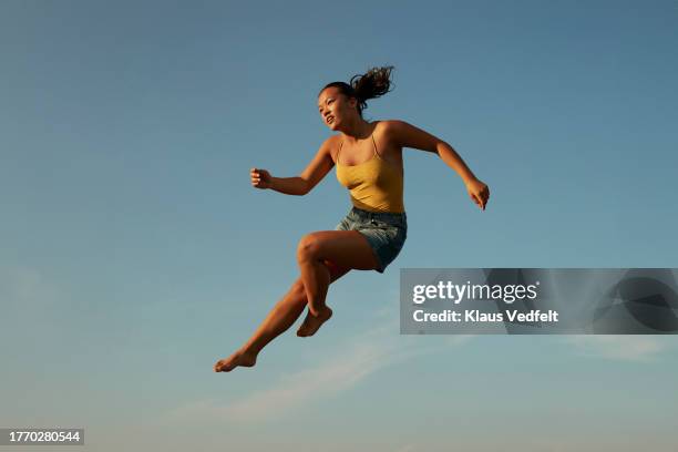 woman doing acrobat in mid air - ponytail stock pictures, royalty-free photos & images