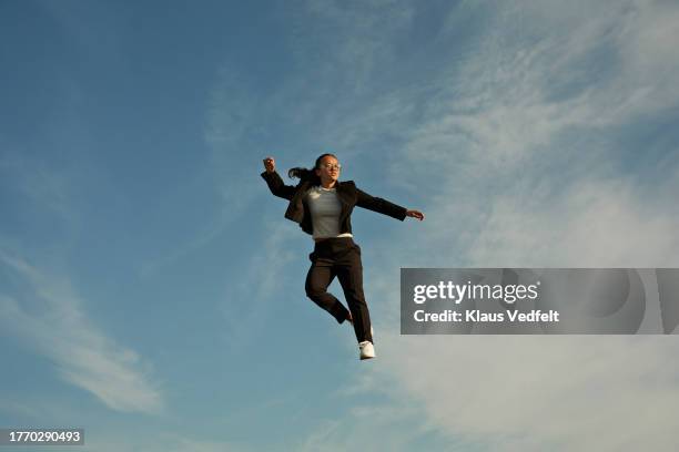 young woman levitating high against blue sky - black high heels stock pictures, royalty-free photos & images