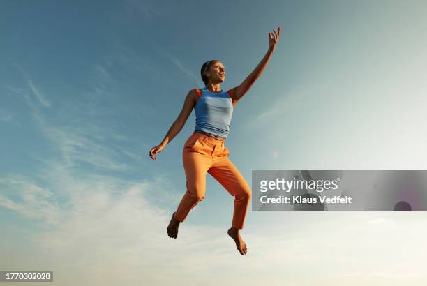 woman with hand raised levitating in mid-air - leap of faith stock pictures, royalty-free photos & images
