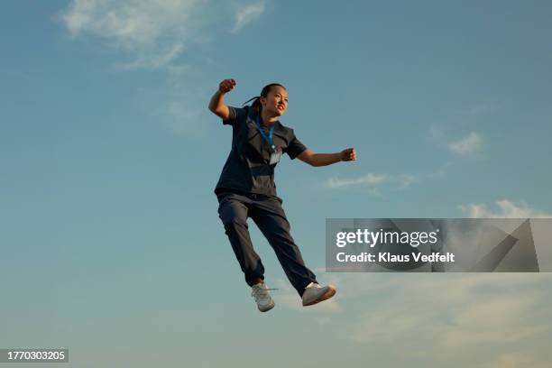 female nurse levitating against blue sky - black high heels stock pictures, royalty-free photos & images