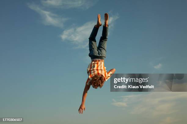 carefree man falling from sky with hand raised - ledematen lichaamsdeel stockfoto's en -beelden