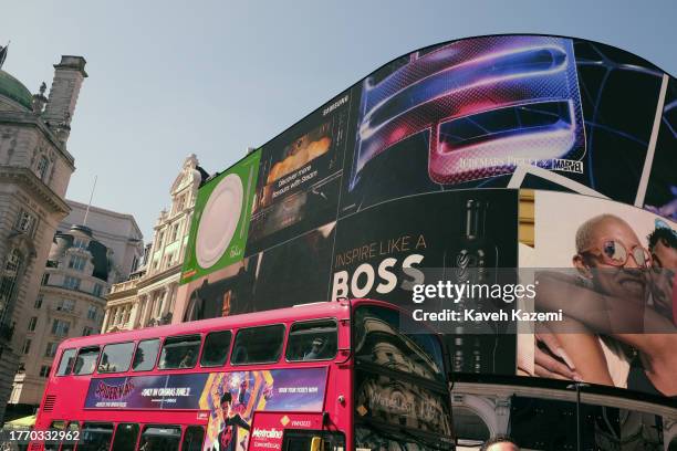 Double-decker Bus passes by huge billboards posted on a building in Piccadilly Circus on June 2, 2023 in London, United Kingdom.