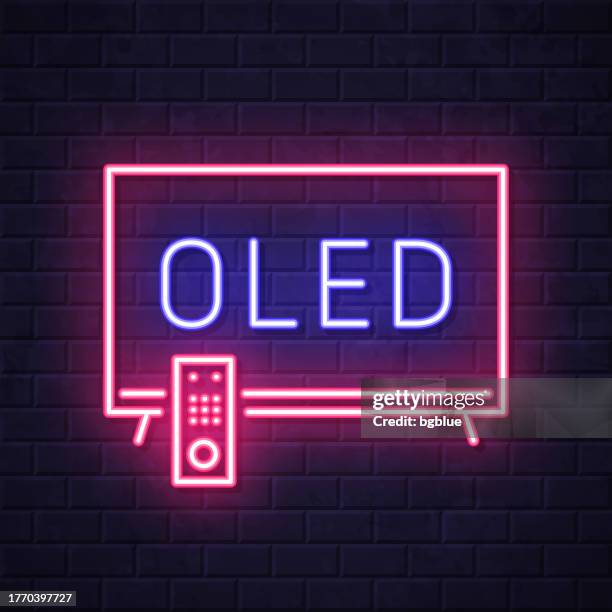 oled-fernseher. leuchtende neon-ikone auf backsteinwandhintergrund - oled stock-grafiken, -clipart, -cartoons und -symbole