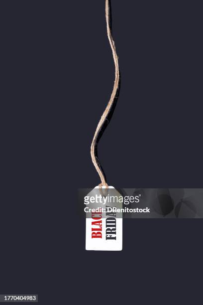 a white tag with string hanging in the center, on a black background that says: 'black friday', in red and black letters. black friday, offers, promotion, cheap prices, sales and consumerism. - f��retag bildbanksfoton och bilder