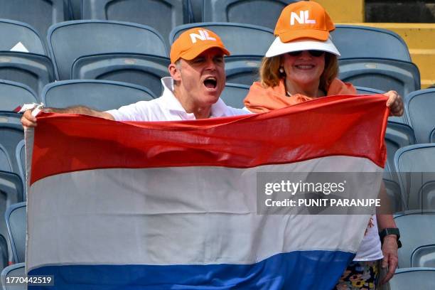 Netherlands fans hold national flag as they cheer during the 2023 ICC Men's Cricket World Cup one-day international match between England and...