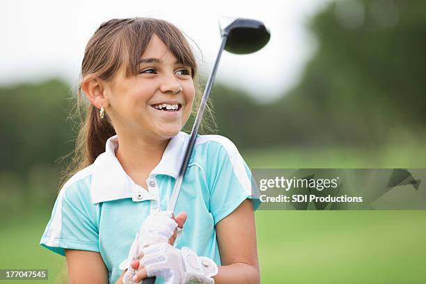 happy little girl playing golf at country club - golf clubhouse stockfoto's en -beelden