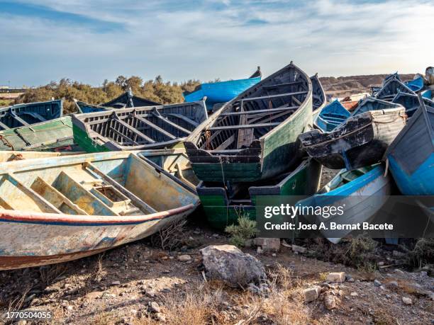 cemetery of wooden boats (cayuco) used to transport immigrants between the canary islands and africa. - emigración e inmigración fotografías e imágenes de stock