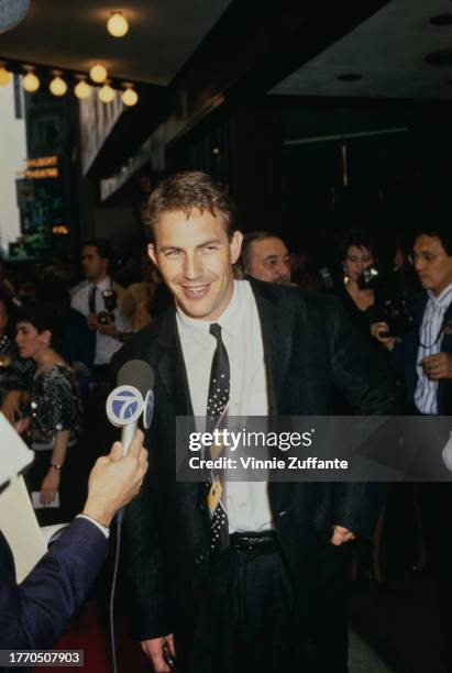 Kevin Costner speaks to a reporter at "The Untouchables" New York City premiere, held at the Lowes Astor Plaza in New York City, New York, United...