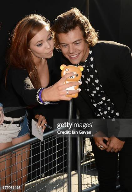 Singer Harry Styles from One Direction with fans as he attends the "One Direction This Is Us" world premiere at the Empire Leicester Square on August...