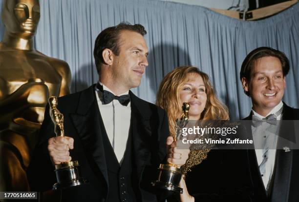Kevin Costner wins the Best Picture and Best Director Oscars at the 63rd Academy Awards, for "Dances with Wolves" . Beside him stands presenter...