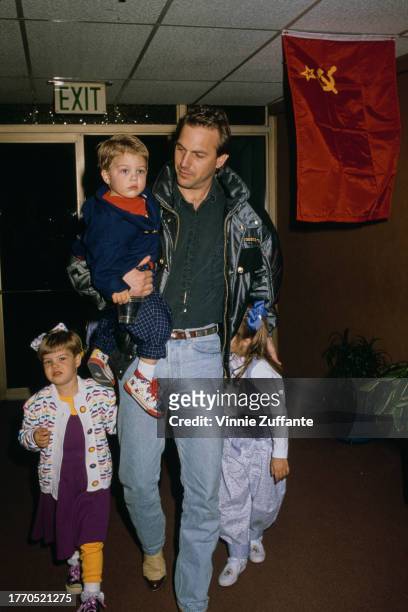 Kevin Costner carrying his son Joe Costner, whilst his daughters Lily and Annie Costner walk beside him, at the Moscow Circus Opening Night...