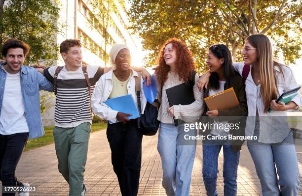 multiethnic group of student friends walking embrace going to school. - last day of school stock pictures, royalty-free photos & images