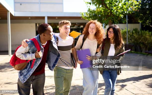 small group of student friends walking out of the school together, talking and laughing. - last day of school stock pictures, royalty-free photos & images