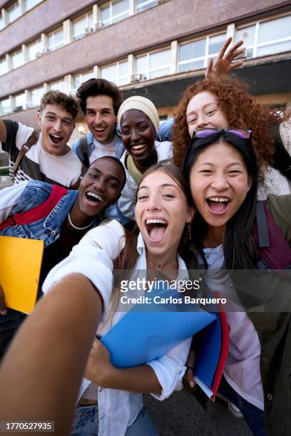 multiethnic classmate taking a selfie outside of the school, looking at camera happily. - last day of school stock pictures, royalty-free photos & images