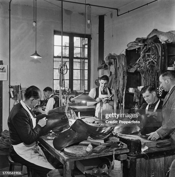 Master saddlers and leatherworkers making racing saddles in the workshop of the Roy Trepess saddler's shop on the High Street in the horse racing...