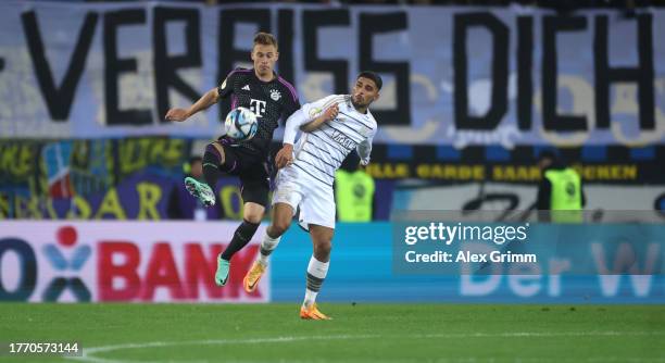 Joshua Kimmich of Bayern Muenchen is challenged by Amine Naifi of 1. FC Saarbrücken during the DFB cup second round match between 1. FC Saarbrücken...