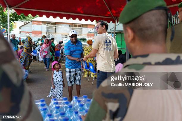 French soldiers help local residents during a distribution of mineral water for the most vulnerable in Cavani neighbourhood of Mamoudzou, on the...