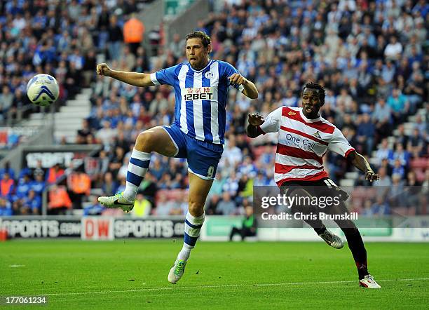 Grant Holt of Wigan Athletic in action with Bongani Khumalo of Doncaster Rovers during the Sky Bet Championship match between Wigan Athletic and...