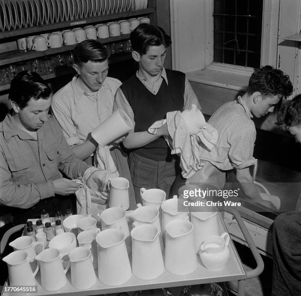 Elevated view of teenage boys washing up an drying dishes at the Outward Bound Mountain School in Eskdale Green, Cumbria, April 1950.