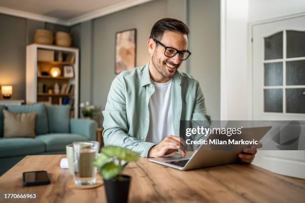 portrait of handsome caucasian man looking at laptop, working online from his home - en människa bildbanksfoton och bilder