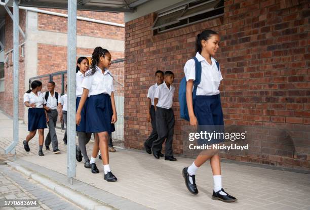 group of students walking to their classroom in school - schooluniform stockfoto's en -beelden