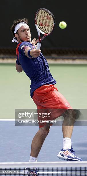 Juan Monaco of Argentina returns a backhand to Nicolas Mahut of France on August 20, 2013 in Winston Salem, North Carolina.