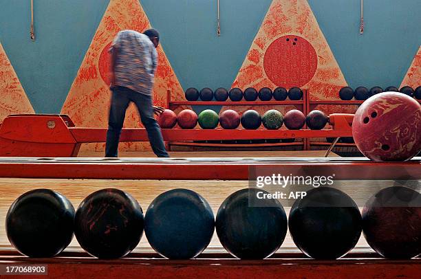 Man picks up a bowling ball in the Asmara bowling alley in Asmara, the capital of Eritrea, on July 20, 2013. Eritrea's capital Asmara boasts...