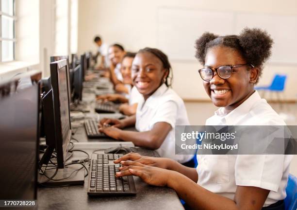 une étudiante apprend à utiliser un ordinateur de bureau en classe d’informatique à l’école - écolière photos et images de collection