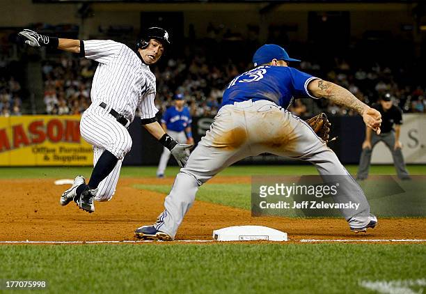 Ichiro Suzuki of the New York Yankees steals third base ahead of a throw to Brett Lawrie of the Toronto Blue Jays during the second game of a double...