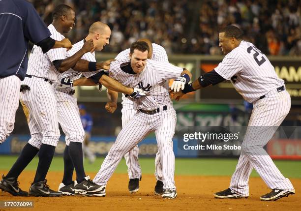 Jayson Nix of the New York Yankees is mobbed by his teamates after hitting a game-winning single in the bottom of the ninth inning against the...