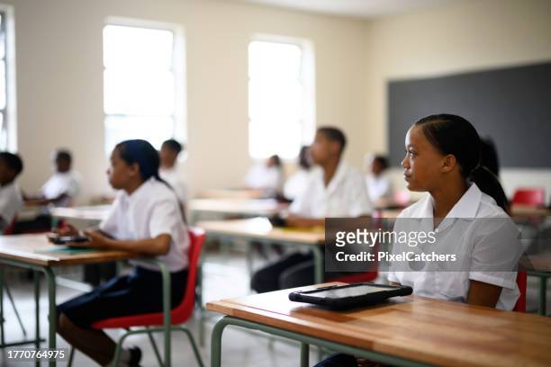 selective focus schoolgirl sitting in class listening to teacher - 12 year old indian girl stock pictures, royalty-free photos & images