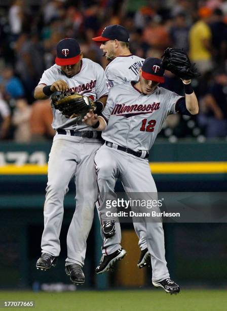 Outfielder Wilkin Ramirez of the Minnesota Twins celebrates a 6-3 win over the Detroit Tigers with Clete Thomas and Chris Herrmann at Comerica Park...