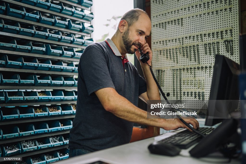 Md Computer Owner Hardware Store Owner Using A Computer While Helping A Customer On The ...