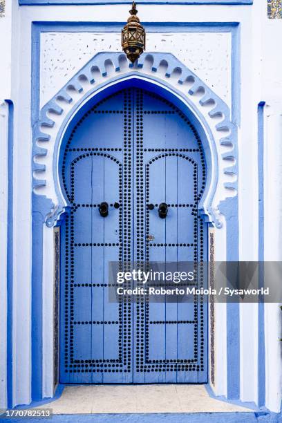 traditional arabic blue painted doorway with knobs - fes morocco stock pictures, royalty-free photos & images
