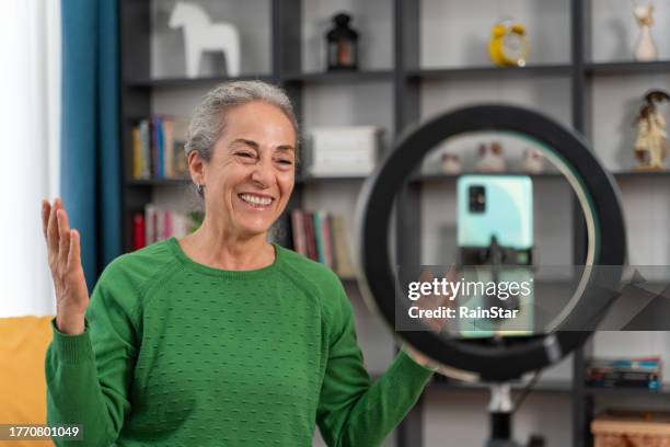 vlogger de mujer mayor haciendo un video de redes sociales - rodar películas fotografías e imágenes de stock