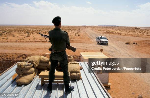Armed guards on sentry duty at a compound housing Bechtel construction workers building the Maghreb-Europe Gas Pipeline in the desert interior of...
